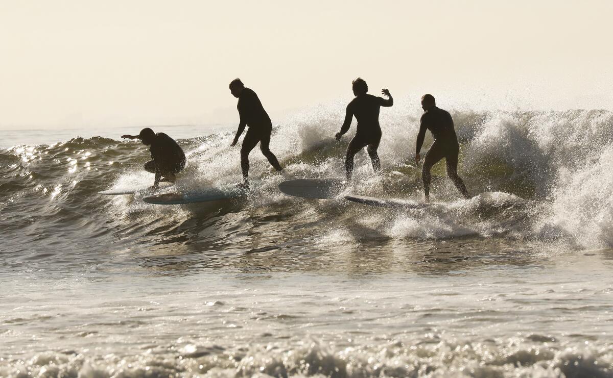 Surfers take advantage of the low tide swell at Malibu Surfrider Beach as Los Angeles County Beaches reopened for active use only.