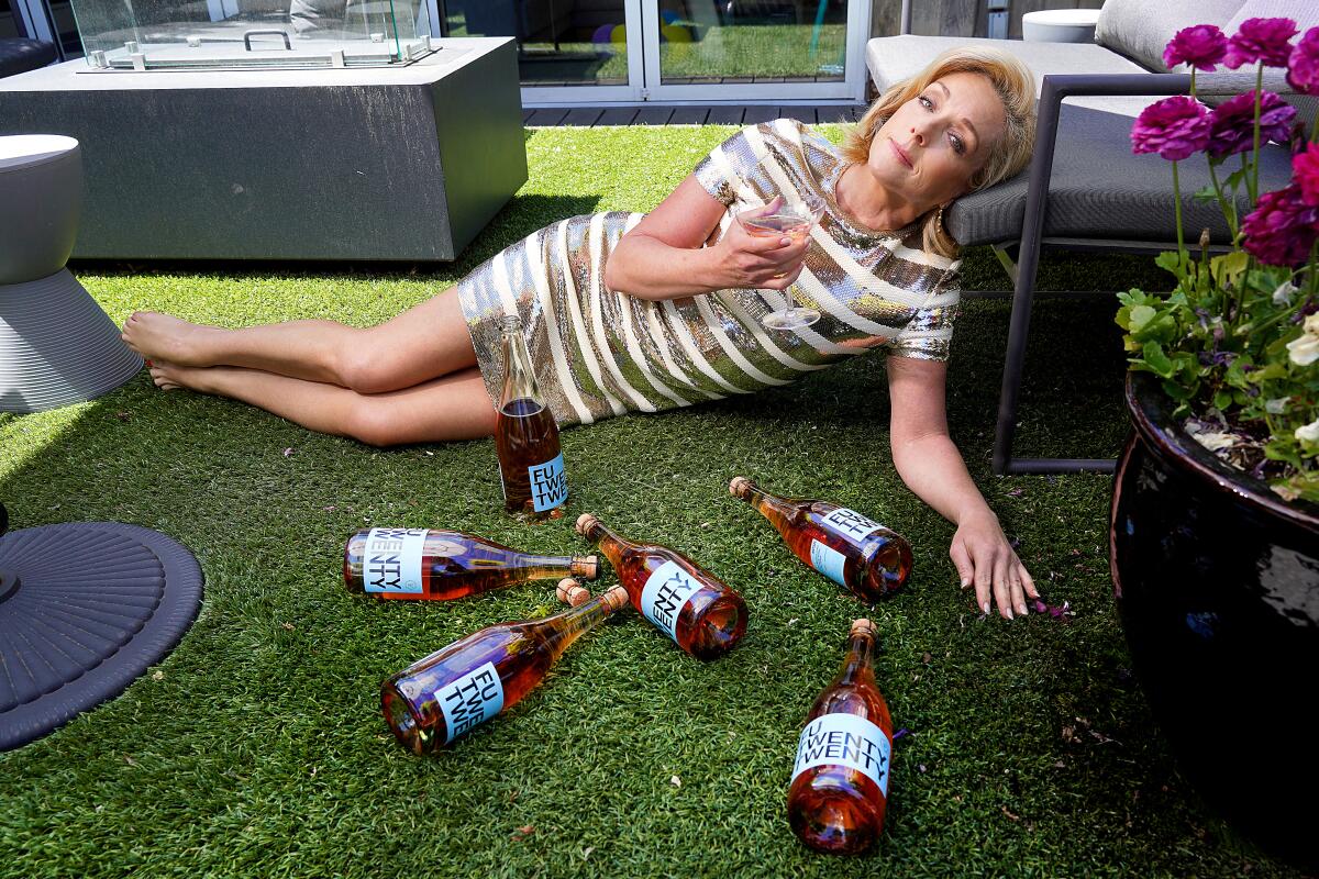 Jane Krakowski ("Dickinson") lies on the floor, surrounded by wine bottles labeled "F-U TWENTY TWENTY."