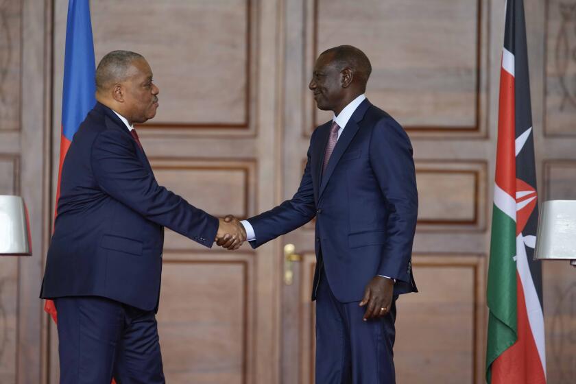 Haiti Prime Minister Garry Conille, left, and Kenya's President William Ruto, right, shake hands after a joint at State House in Nairobi, Kenya, Friday, Oct. 11, 2024. (AP Photo/Brian Inganga)