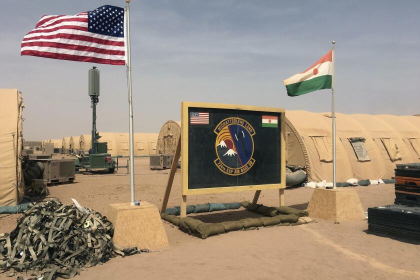 FILE- In this file photo taken Monday, April 16, 2018, a U.S. and Niger flag are raised side by side at the base camp for air forces and other personnel supporting the construction of Niger Air Base 201 in Agadez, Niger. The US handed over its last military base in Niger to the country's authorities, the US Department of Defense and Niger’s Ministry of Defense announced in a joint statement on Monday, Aug. 5, 2024. (AP Photo/Carley Petesch, File)