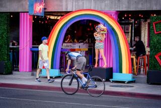A person on a bike rides along Santa Monica Blvd. in West Hollywood