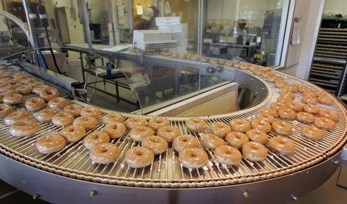 Doughnuts roll by on a conveyor at a Krispy Kreme store in Charlotte, N.C.