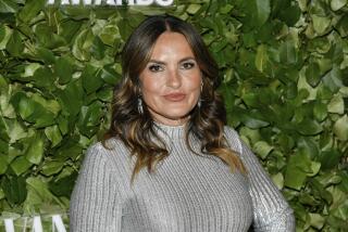 Mariska Hargitay poses in a silver turtleneck in front of foliage backdrop at the 2024 Gotham TV Awards in New York