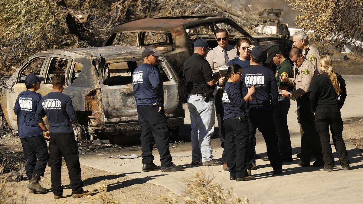 Los Angeles County coroner's workers on the scene where a body was found at a burned home in the 32000 block of Lobo Canyon Road in Agoura Hills.