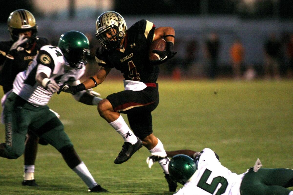 Brandon Pierce attempts to go between defenders Kristian Hanley and Aaron Corbin during Alemany's victory over Narbonne, 42-14, on Friday.