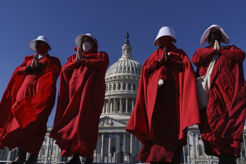 Activists opposed to the Trump presidency are dressed as characters from the dystopian "Handmaid's Tale," as they demonstrate at the Capitol on Election Day, Tuesday, Nov. 3, 2020, in Washington. (AP Photo/J. Scott Applewhite)