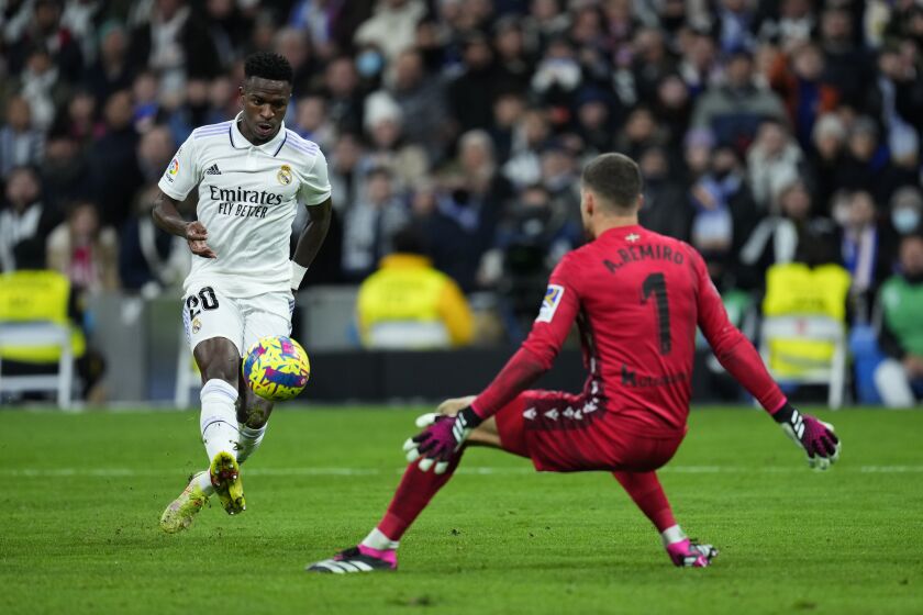 Real Madrid's Vinicius Junior, left, takes a shot on goal in front of Real Sociedad's goalkeeper Alex Remiro during the Spanish La Liga soccer match between Real Madrid and Real Sociedad, at the Santiago Bernabeu stadium in Madrid, Sunday, Jan. 29, 2023. (AP Photo/Manu Fernandez)