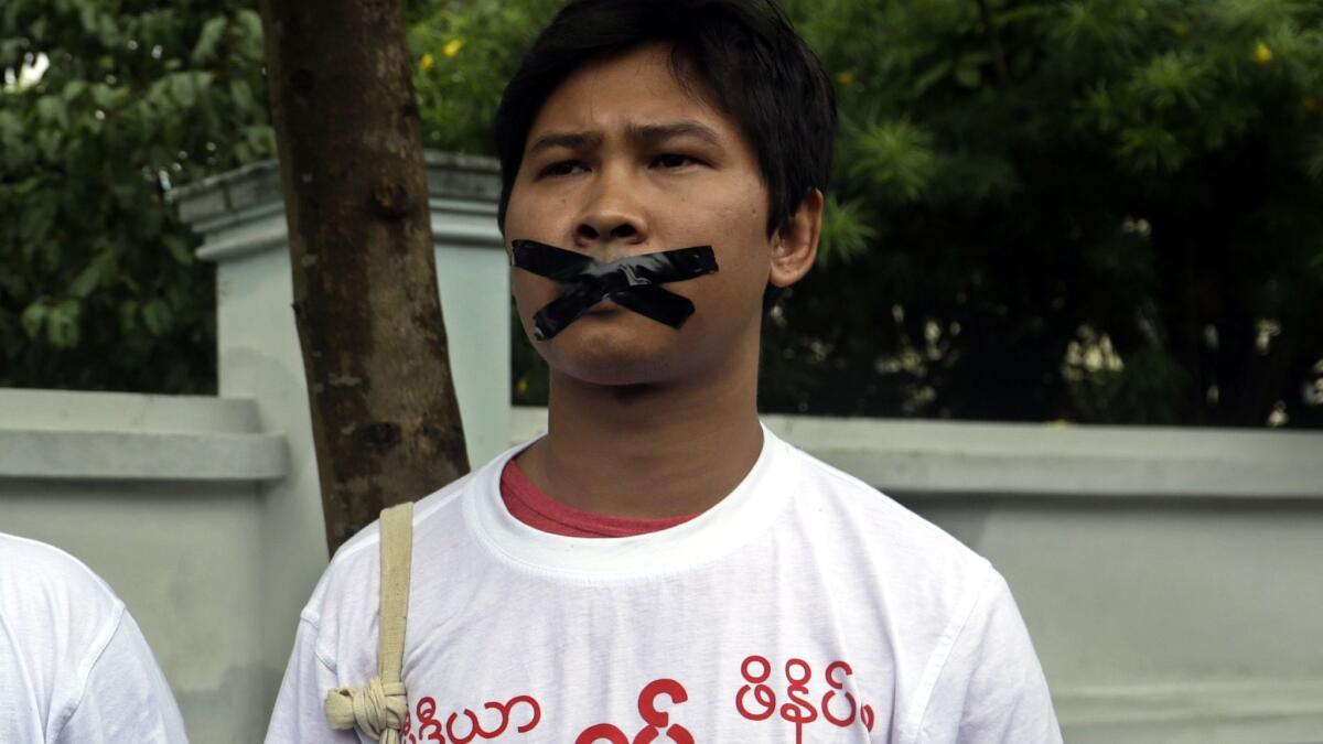 Reuters journalist Wa Lone tapes his mouth in a protest over his jailed colleagues on December 12 in Myanmar.