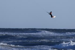Huntington Beach, CA - January 07: A windsurfer takes advantage of strong, gusty winds to take flight amid high surf in in Huntington Beach Sunday, Jan. 7, 2024. (Allen J. Schaben / Los Angeles Times)