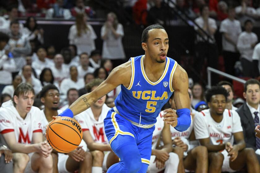 UCLA guard Amari Bailey (5) drives to the basket during the first half of an NCAA college basketball game Maryland, Wednesday, Dec. 14, 2022, in College Park, Md. (AP Photo/Terrance Williams)