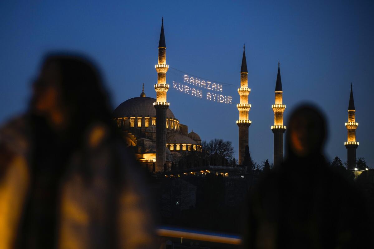 A message in lights appears between minarets 
