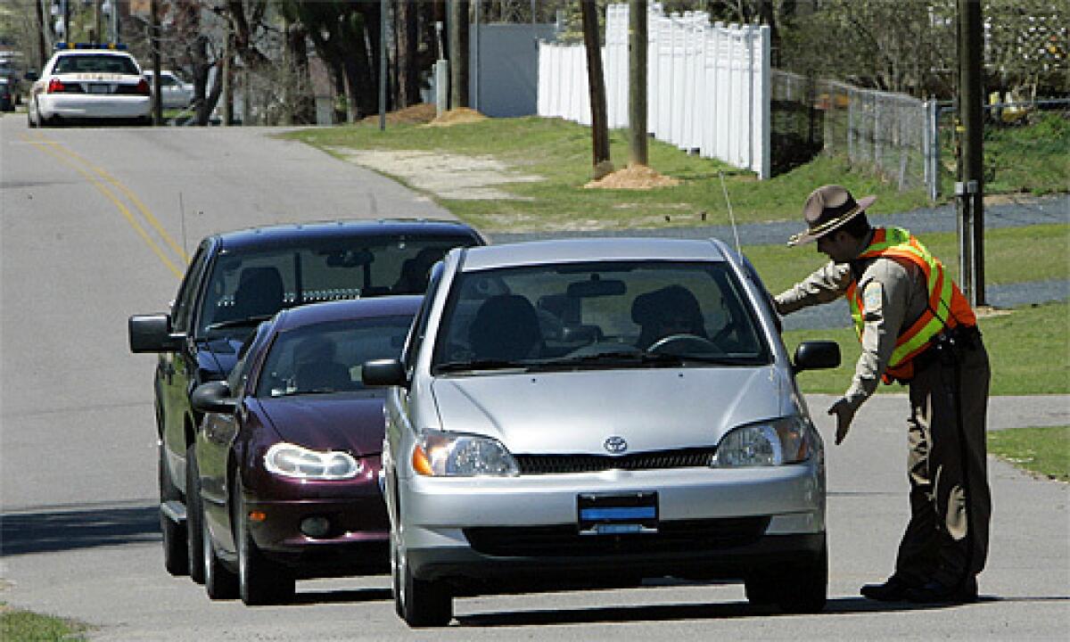 A sheriff's deputy redirects traffic from the area where a gunman opened fire at Pinelake Health and Rehab in Carthage, N.C.