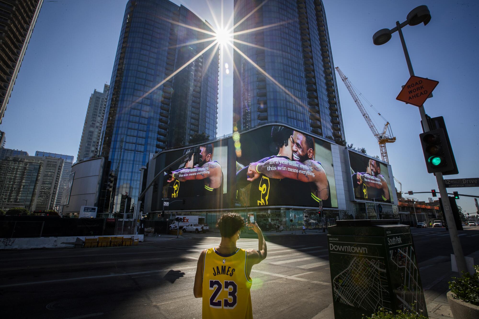 Lakers fan Michael Vasquez, of Buena Park, takes video of giant screens across from the Staples Center.