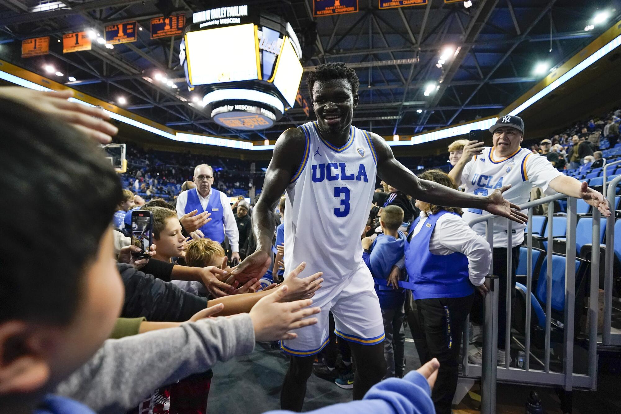 UCLA center Adem Bona (3) greets fans as he leaves the court after a 68-54 win over Colorado.