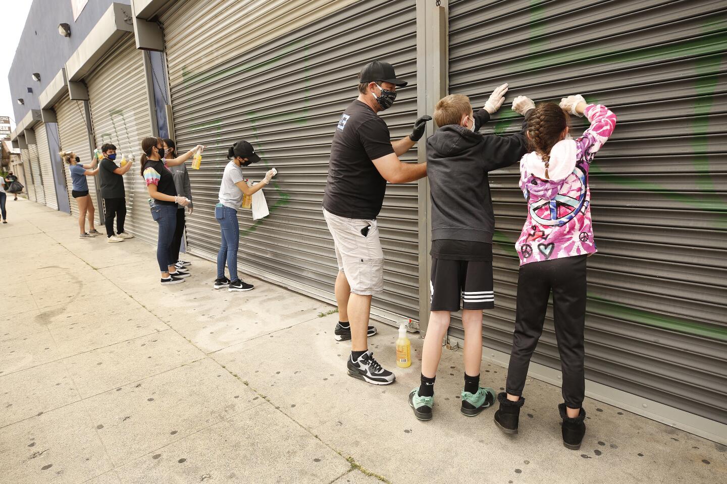 Volunteers help to remove graffiti from store on Van Nuys Blvd.