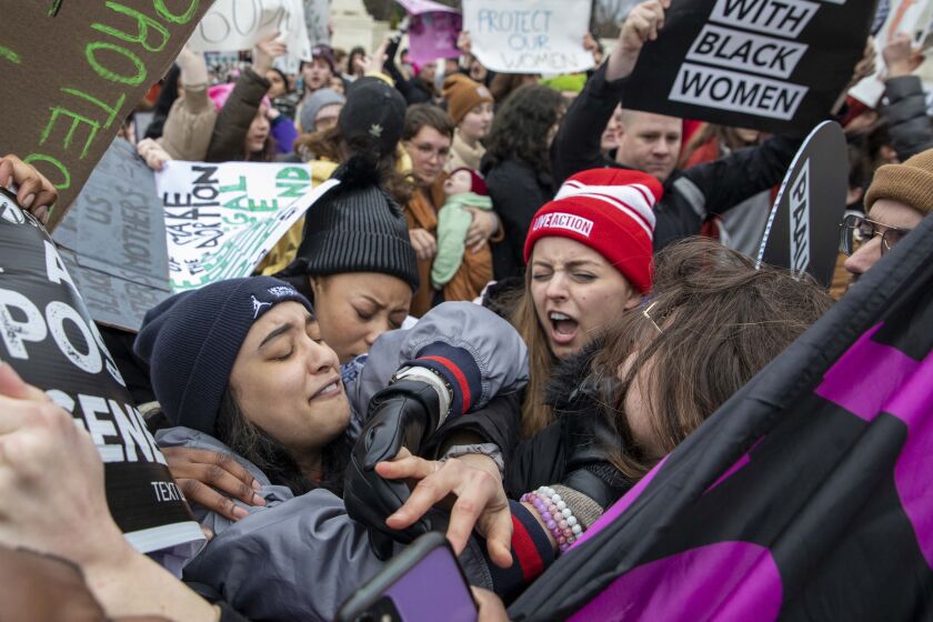 Una manifestante en favor del aborto y otra que se opone a él se enfrentan ante la Corte Suprema durante la Marcha de las Mujeres, enfocada en gran medida en el derecho a la interrupción del embarazo, el domingo 22 de enero de 2023, en Washington. (AP Foto/Amanda Andrade-Rhoades)