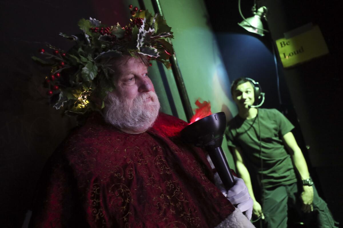 James Tarbert, playing Christmas Present, waits for his cue to go on stage as stage manager left Tyler Phillips sits in his position during a dress rehearsal of the Julian Theater Company's "A Christmas Carol."