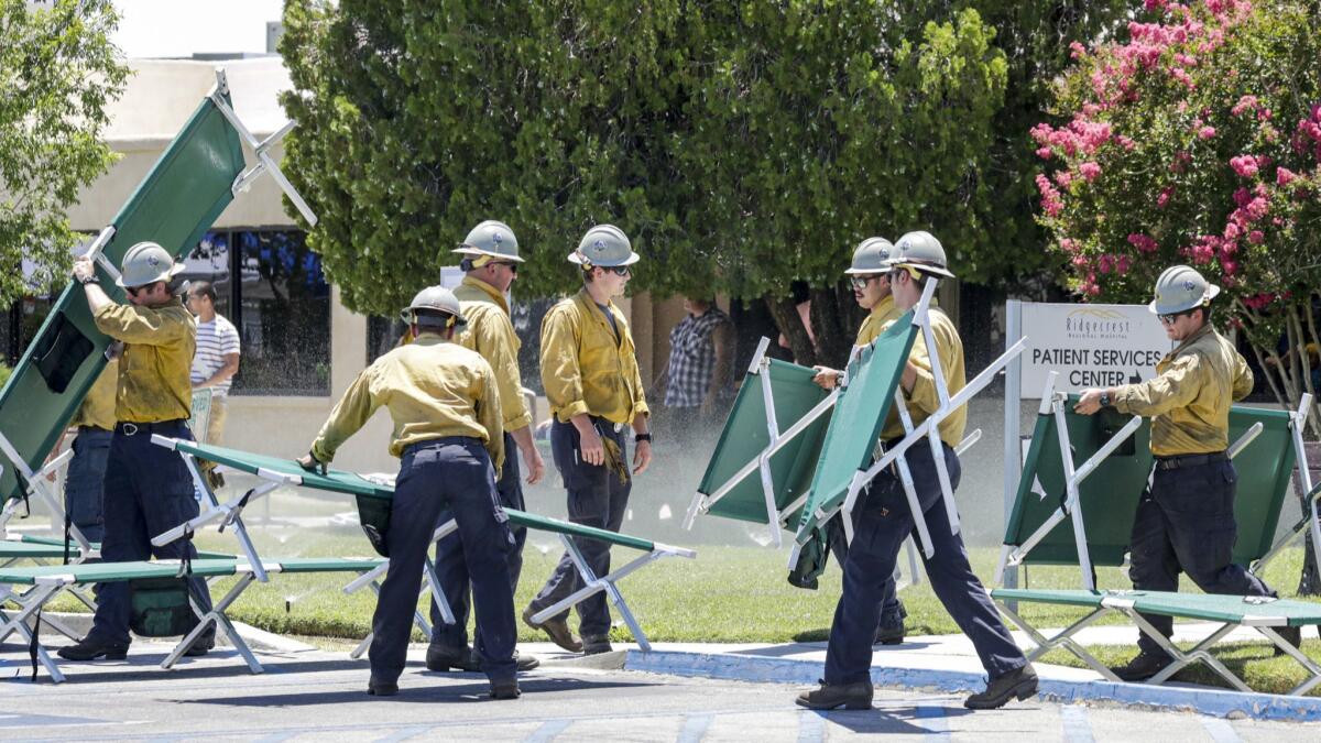 Firefighters set up cots outside Ridgecrest Regional Hospital after Thursday's 6.4 earthquake near Ridgecrest, Calif.