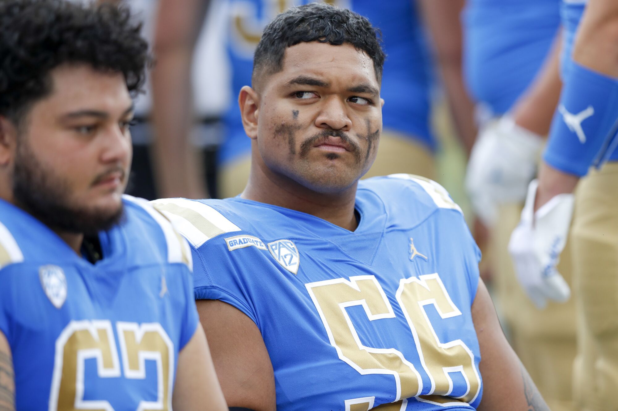 UCLA Bruins offensive lineman Atonio Mafi (56) sits on the bench during a college football game