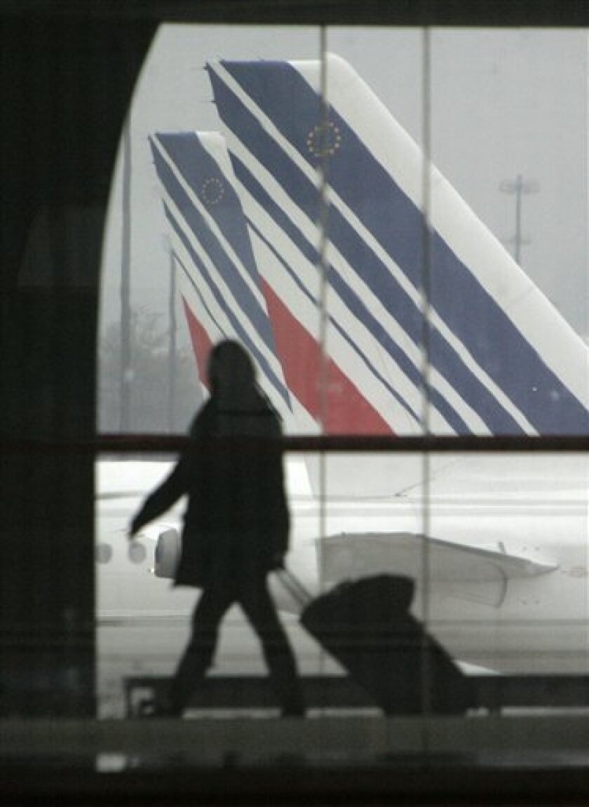 A passenger walks past tails of Air France planes at Roissy airport, outside Paris, Friday Nov. 14 , 2008. A four-day pilots' strike starts Friday and the walkout has been called to protest the French parliament's upcoming discussion of a reform bill that could extend the retirement age for pilots from 60 to 65. (AP Photo/Jacques Brinon)