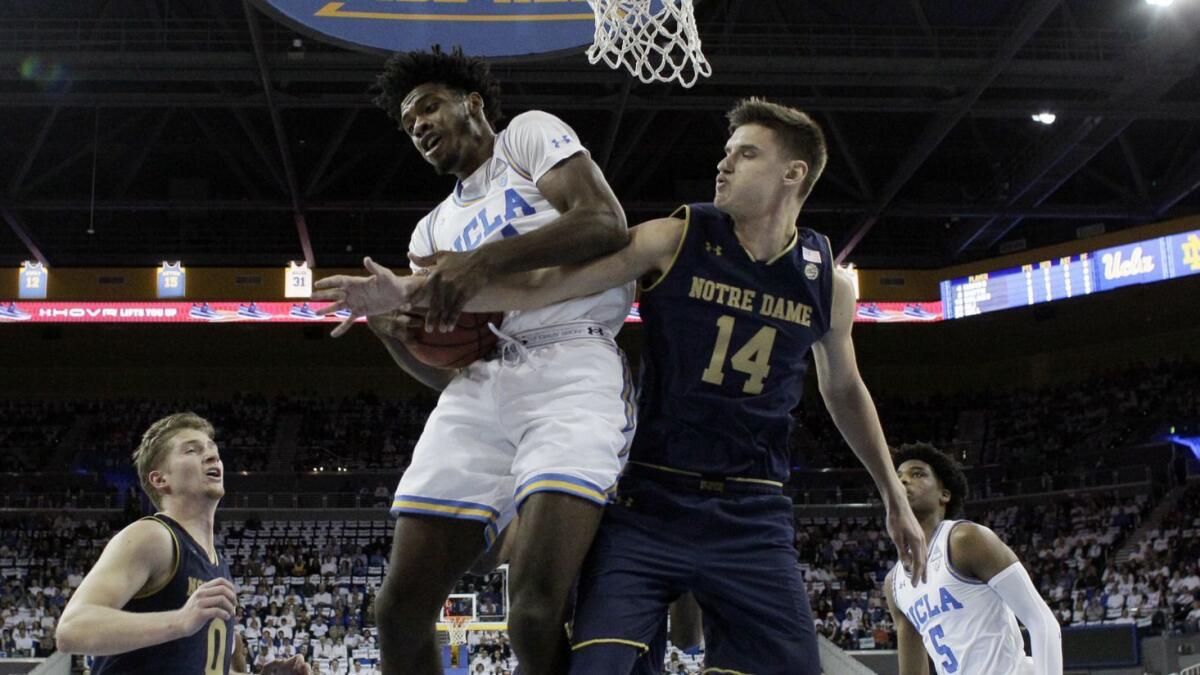 UCLA forward Jalen Hill grabs a rebound against Notre Dame forward Nate Laszewski during their game Dec. 8.