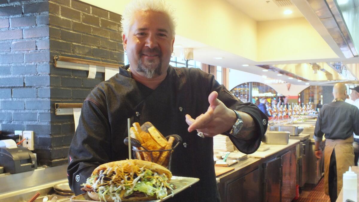 Celebrity chef Guy Fieri serves up one of his overstuffed El Jefe Hamburguesas at El Burro Borracho, his new restaurant in Las Vegas.
