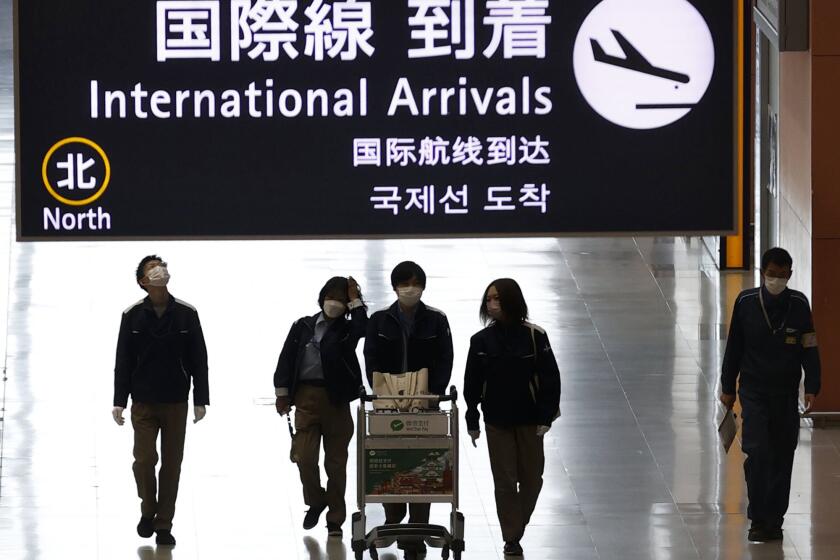 Passengers walk at the lobby for the international arrivals at Kansai International Airport in Osaka, western Japan, Tuesday, Nov. 30, 2021. Japan confirmed on Tuesday its first case of the new omicron coronavirus variant, a visitor who recently arrived from Namibia, an official said.(Yukie Nishizawa/Kyodo News via AP)