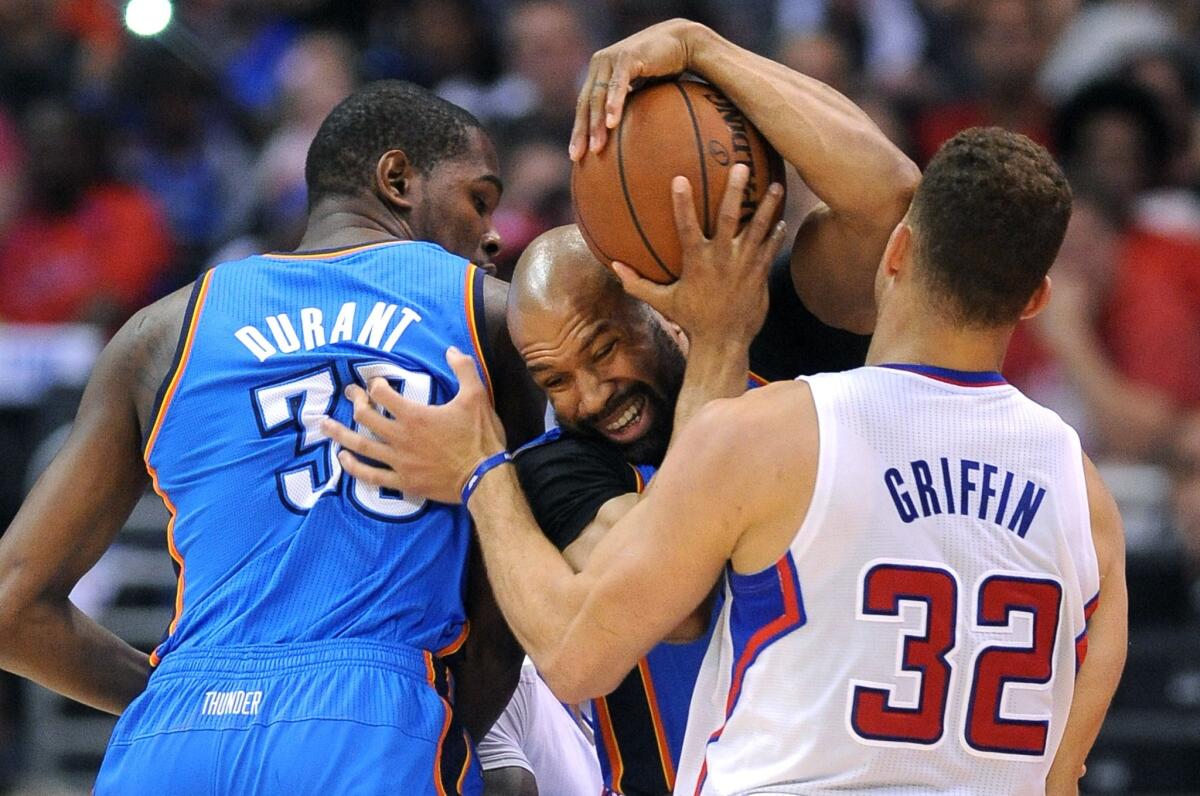 Thunder guard Derek Fisher, caught between teammate Kevin Durant and Clippers forward Blake Griffin, tries to keep control of the ball in Game 4.