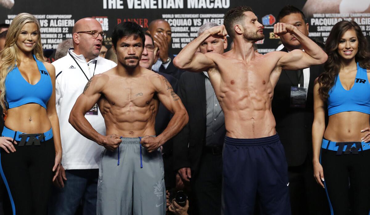 WBO welterweight champion Manny Pacquiao, left, and WBO junior-welterweight champion Chris Algieri strike poses during the weigh-in for their fight in Macao.