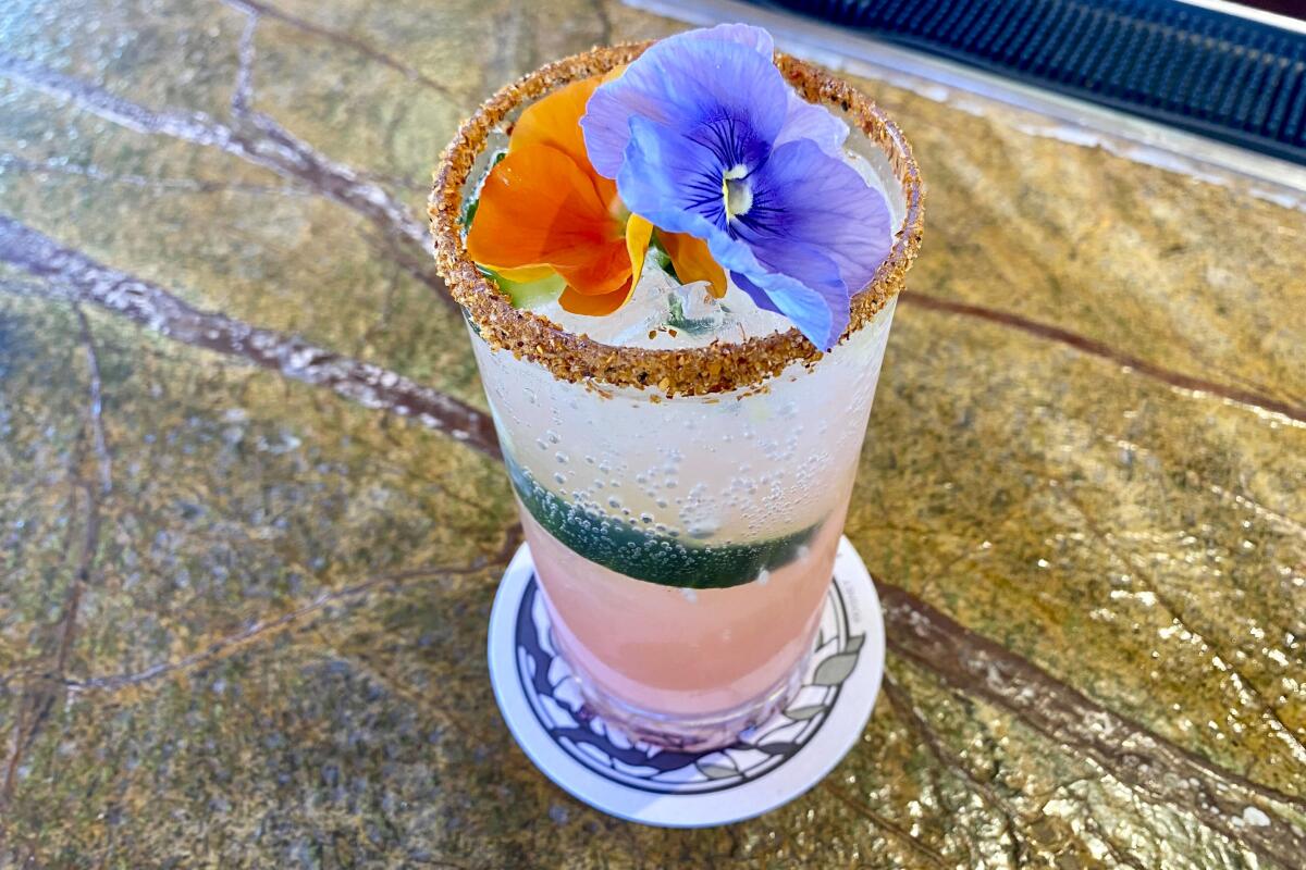 Flowers top a colorful drink.