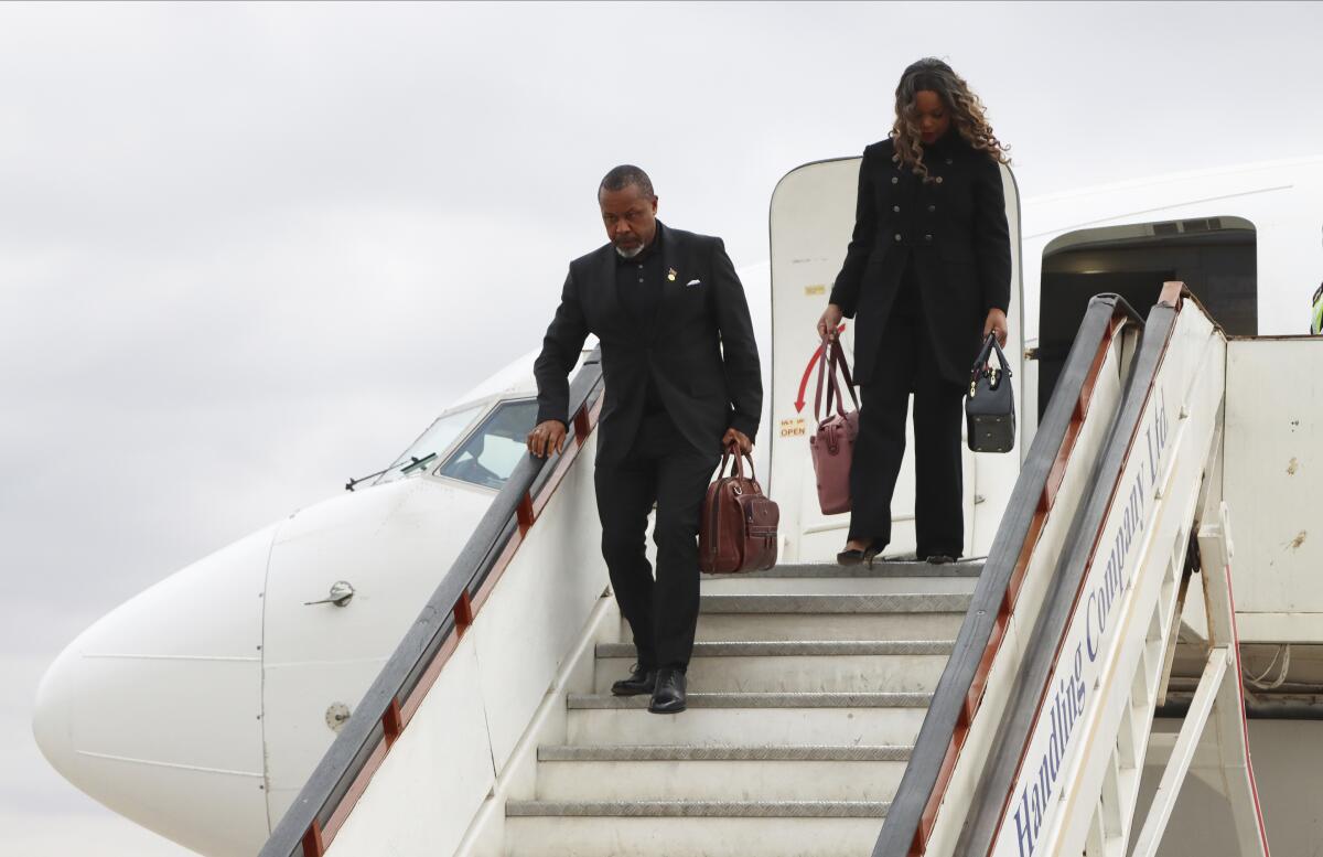 Malawi Vice President Saulos Chilima, left, and his wife Mary disembark from a plane.