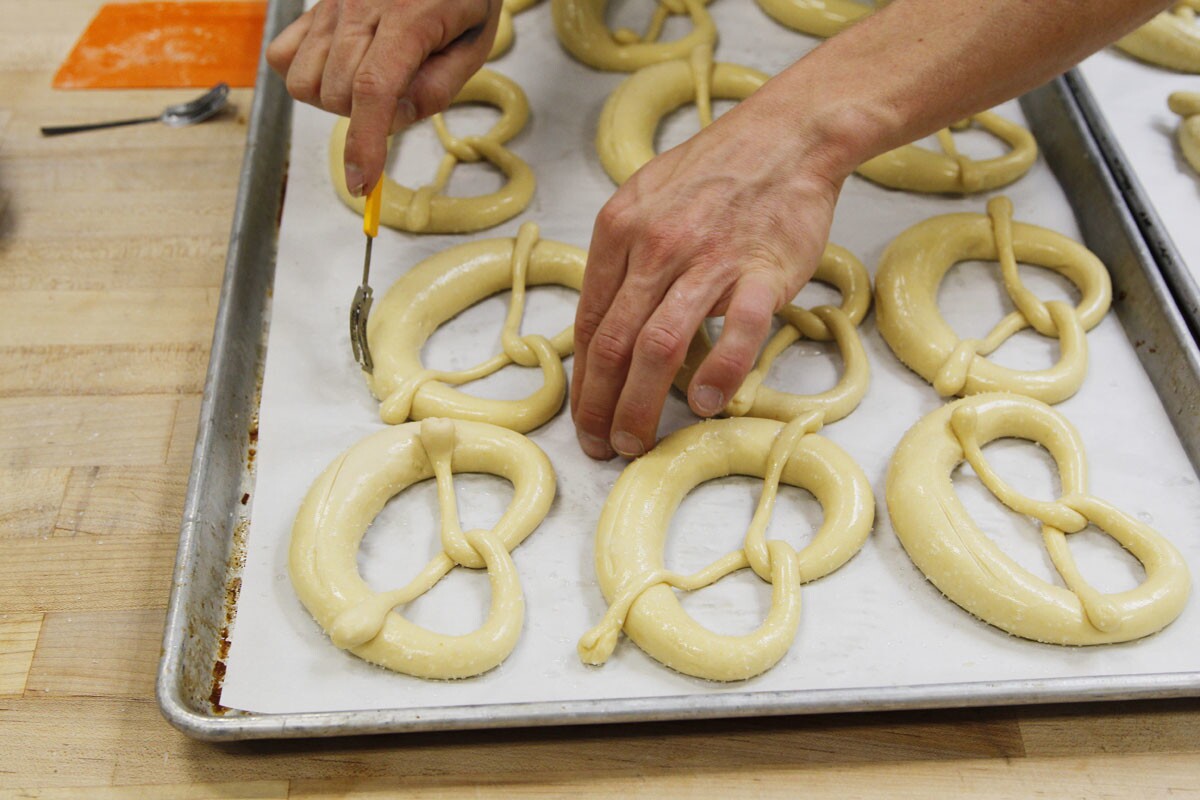 Prager Brothers Artisan Breads co-owner Clinton Prager prepares pretzels for baking on Wednesday in Carlsbad.