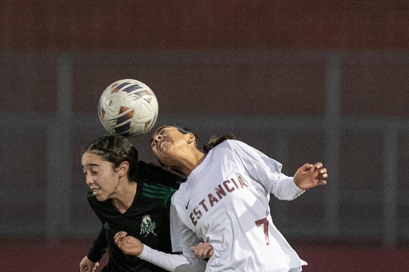 Costa Mesa's Alexys Lopez, left, goes up for a header against Estancia's Ana Pacheco