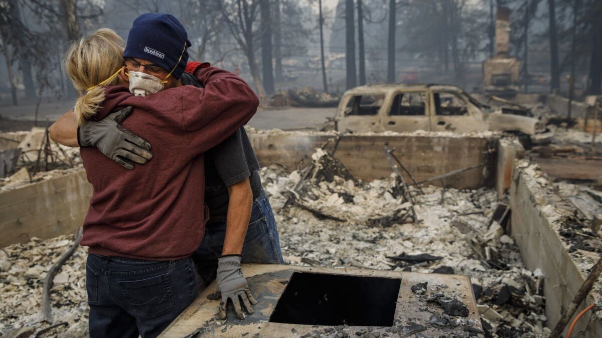 Michael John Ramirez hugs his wife, Charlie, after they found her keepsake bracelet in the rubble of their Paradise, Calif., home that was consumed by the Camp fire.