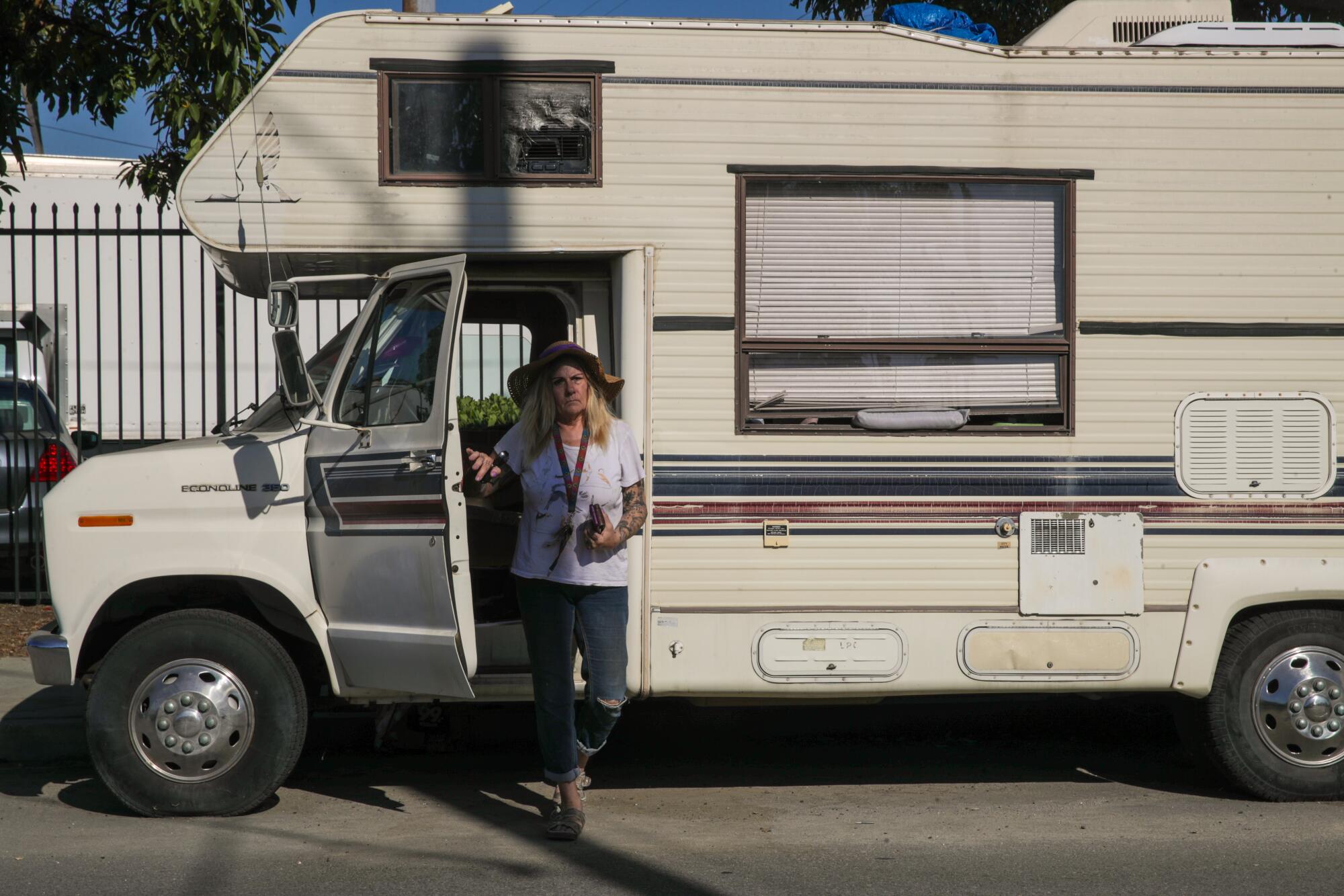 A person exits the driver's door of an RV.