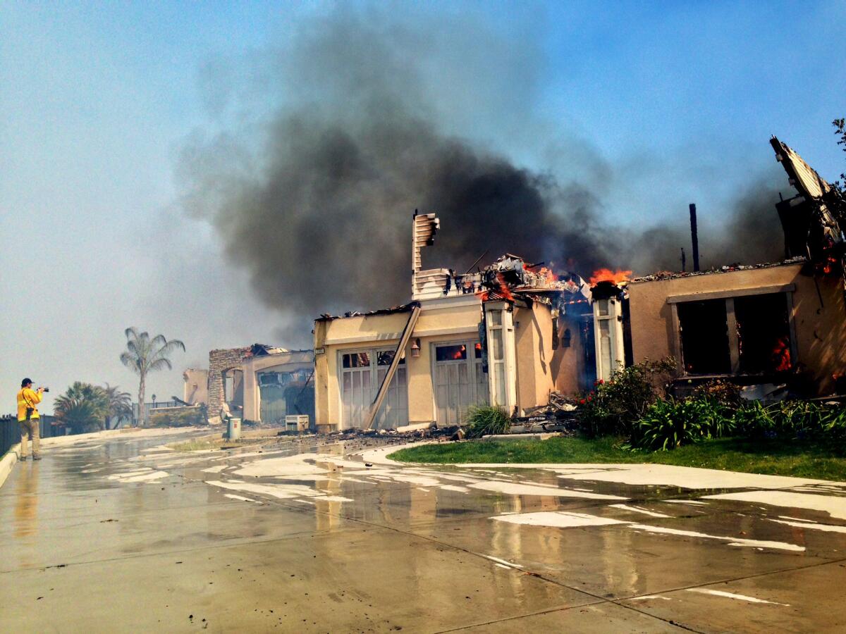 A home is destroyed by the brush fire in Carlsbad off Poinsettia Lane near the 5 Freeway.