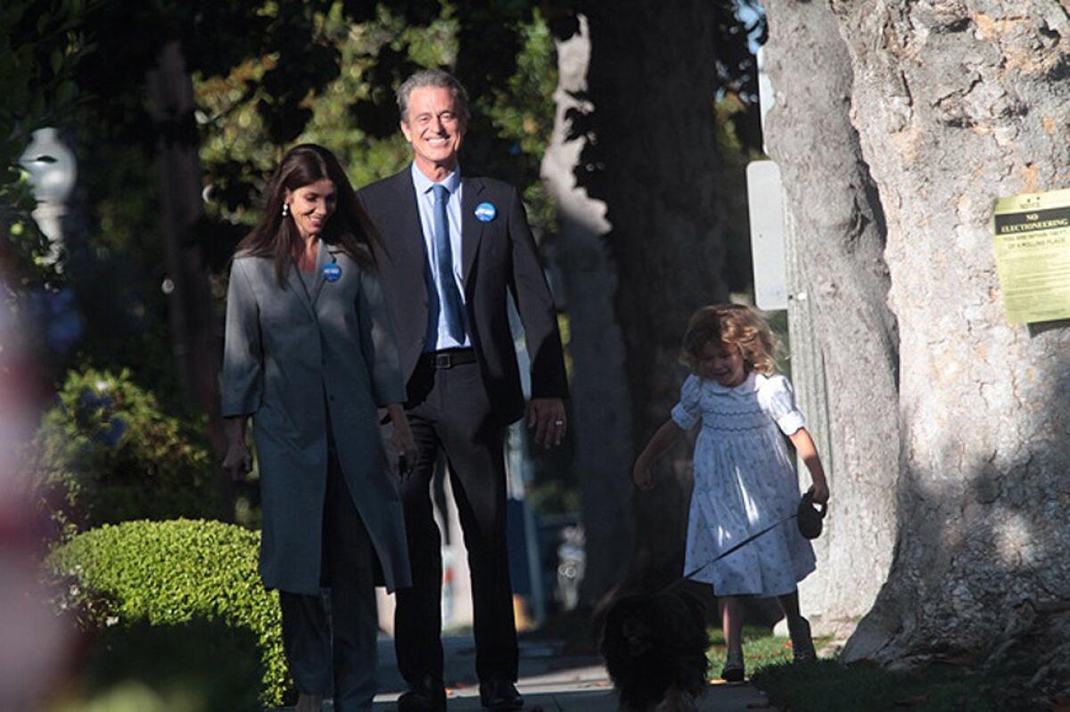 Los Angeles County supervisorial candidate Bobby Shriver, his wife Malissa, daughter, Rosemary, 5, and dog Jack walk up to their polling place in Santa Monica Tuesday morning.