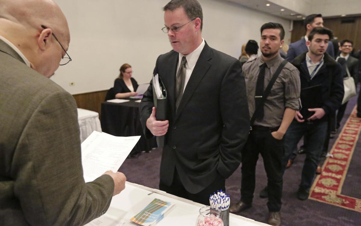 En esta foto del 22 de abril de 2015, Ralph Logan, gerente de Microtrain, izquierda, habla con James Smith, quien bisca trabajo, en Chicago. Los empleadores estadounidenses crean 292.000 puestos de trabajo en diciembre, una indicación de que la economía del país va a contraflujo de las tendencias globales y crece a buen paso. El Departamento de Trabajo dice el jueves 8 de enero de 2016 que la tasa de desempleo sigue en 5% por tercer mes consecutivo. Más estadounidenses se lanzaron a buscar trabajo y lo consiguieron. (AP Foto/M. Spencer Green)