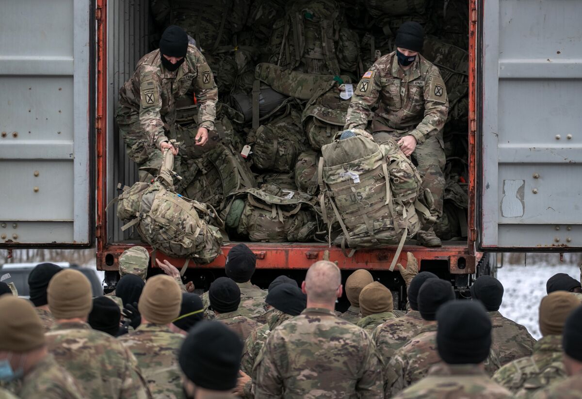 U.S. Army soldiers wait as their duffels are unloaded from a truck upon their return to Ft. Drum, N.Y., from Afghanistan.