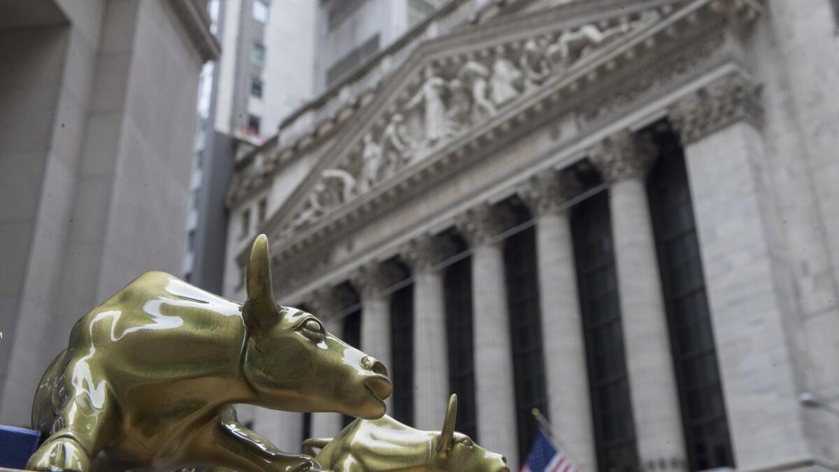 Small replicas of Arturo Di Modica's "Charging Bull" statue are displayed on a street vendor's table outside the New York Stock Exchange.