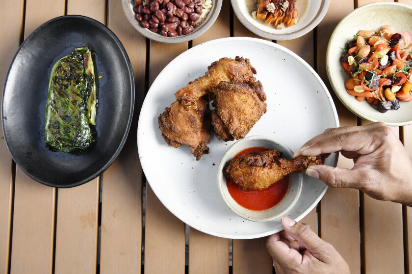 Skillet fried chicken with a side of collard greens, glazed carrot, candied yam gratin, rice and beans.