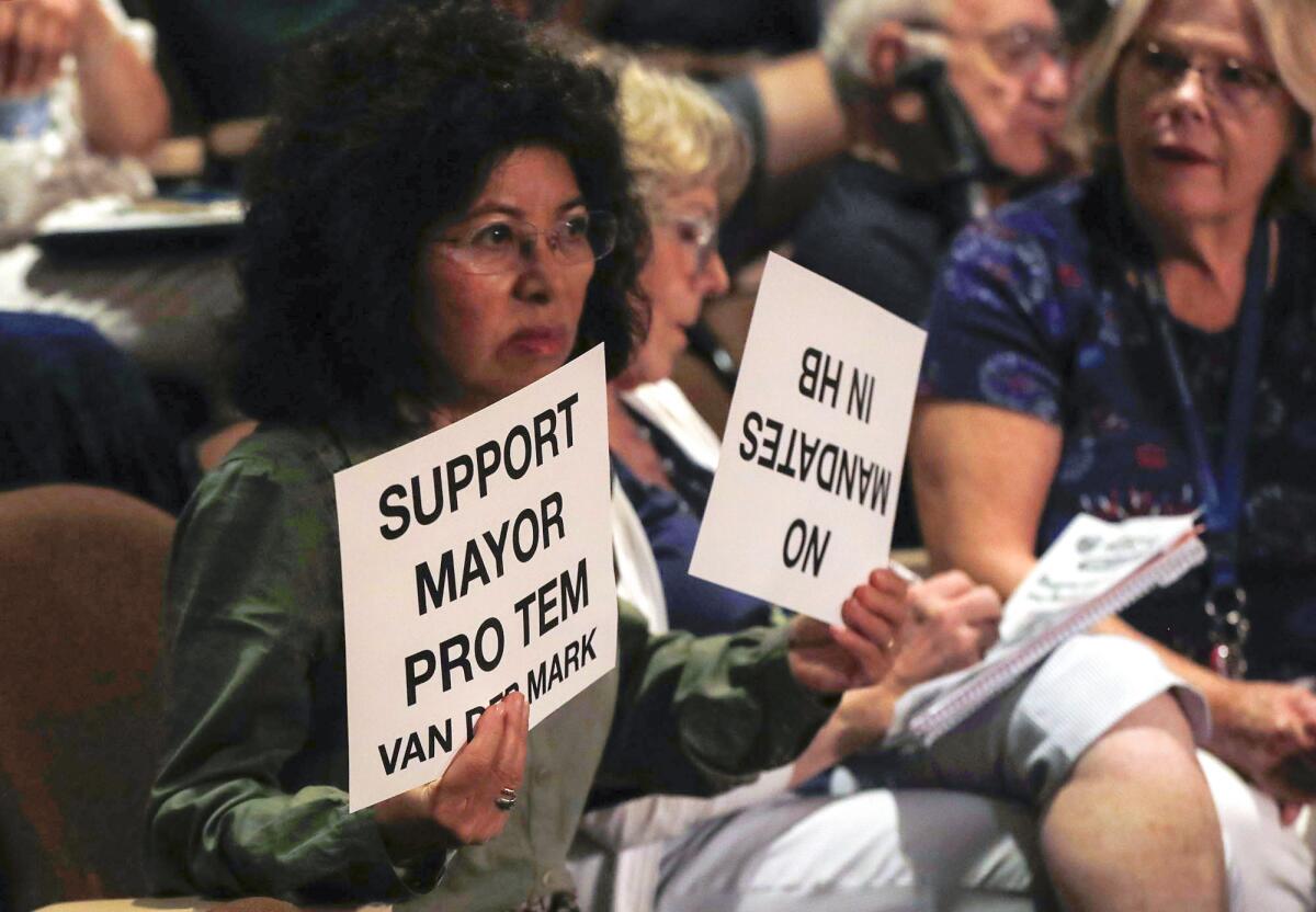 A woman shows her support for Mayor Pro Tem Gracey Van Der Mark at Tuesday's meeting.
