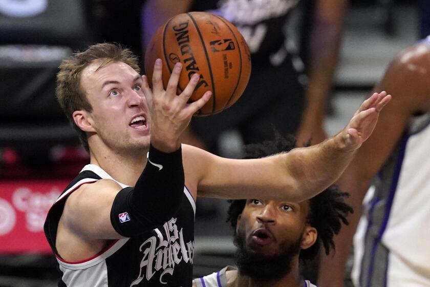 Los Angeles Clippers guard Luke Kennard, left, shoots as Sacramento Kings forward Marvin Bagley III watches during the first half of an NBA basketball game Sunday, Feb. 7, 2021, in Los Angeles. (AP Photo/Mark J. Terrill)