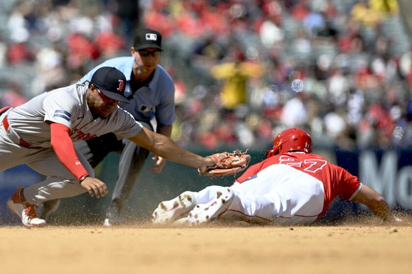 Boston Red Sox second baseman Enmanuel Valdez, left, misses on a tag as Los Angeles Angels' Mike Trout (27) steals second during the third inning of a baseball game in Anaheim, Calif., Sunday, April 7, 2024. (AP Photo/Alex Gallardo)