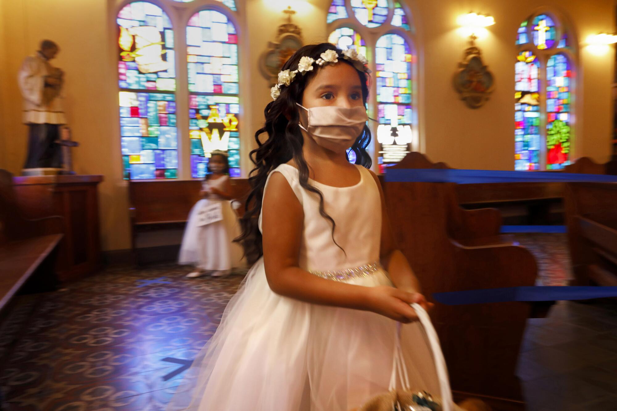 Flower girl Mia Cedillo, 5, wore a face mask at a family wedding at Our Lady of Guadalupe Catholic Church.