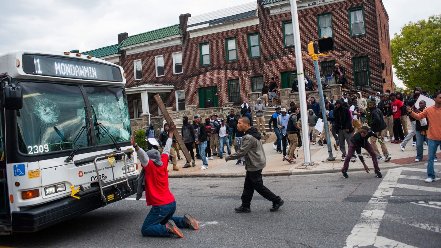 Demonstrators block a damaged bus at Baltimore's Mondawmin Mall during a protest Monday over the death of Freddie Gray.
