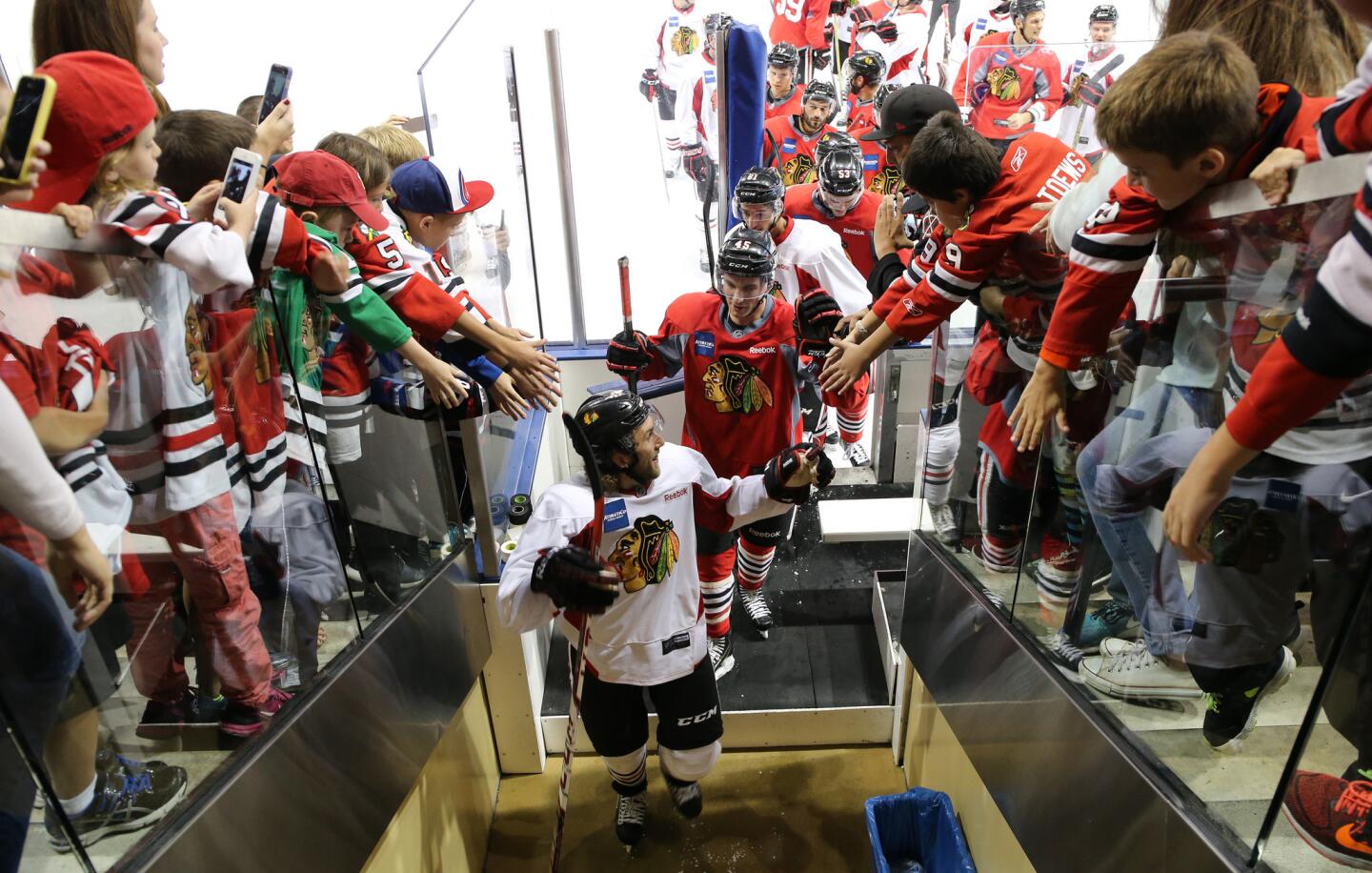Blackhawks players receive high fives from fans following a scrimmage game at Blackhawks training camp.