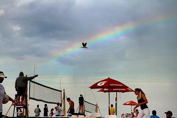 An early morning rainbow breaks through the cloud cover Friday at the AVP Hermosa Beach Open volleyball tournament being held this weekend. See full story