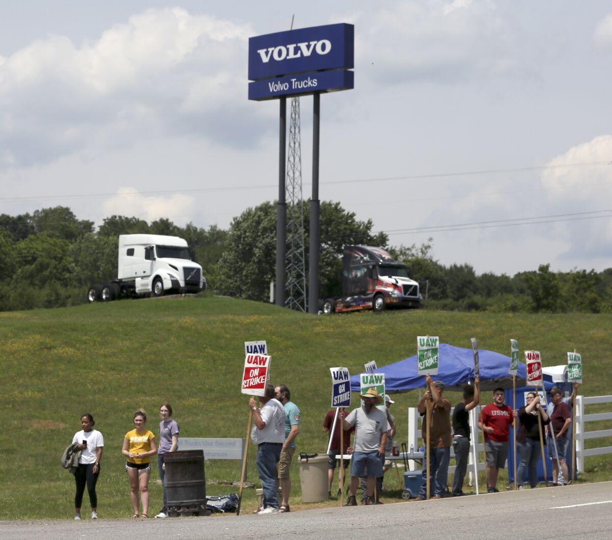 FILE - In this June 18, 2021 file photo, UAW Members strike outside the Volvo Trucks North America plant in Dublin, Va. With Help Wanted signs at factories and businesses spreading across the nation, in manufacturing and in service industries, union workers like those at the Volvo site are seizing the opportunity to try to recover some of the bargaining power — and financial security — they feel they lost in recent decades as unions shrank in size and influence. (Matt Gentry/The Roanoke Times via AP)