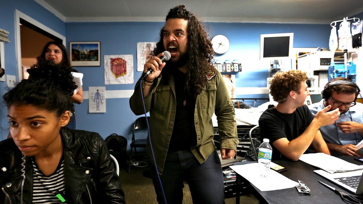 Cyrus Ghahremani, center, is head of Super Deluxe’s live programming group and doubles as the baritone announcer for its live telenovela. (Rick Loomis / Los Angeles Times)